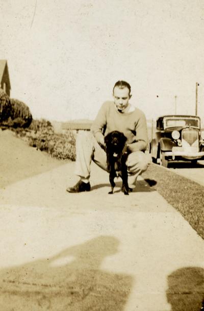 Robert Crookham playing with a dog, ca. 1930s.