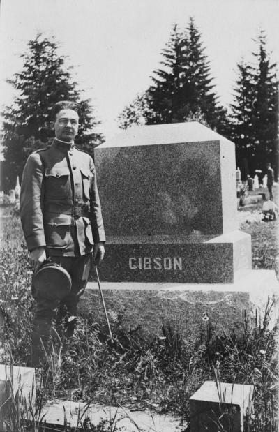 Vane Gibson, in his cadet uniform, standing next to his family's cemetery plot, ca 1930s.
