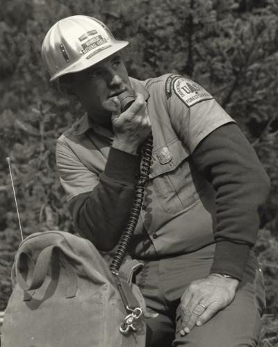 A United States Forest Service Ranger using a portable radio.
