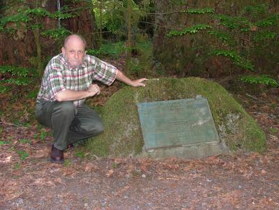 Gerald Williams posing with the Gifford Pinchot National Forest marker