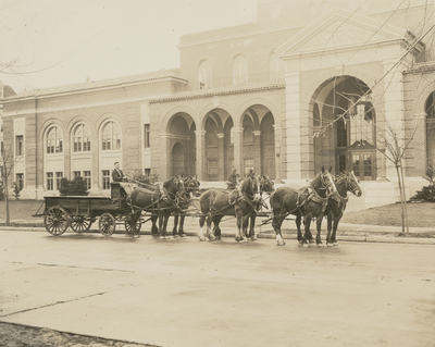 Clydesdales mounted to a wagon and standing adjacent to the Women&#039;s Building