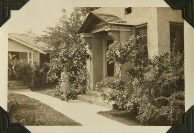 Black and white photographs of Roger and Betty Hayward posing in front of their home.