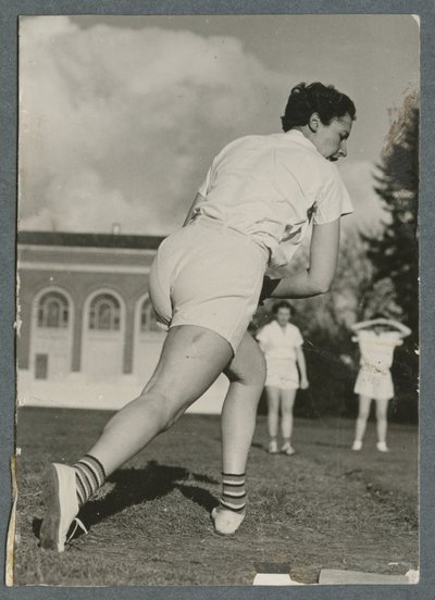 Women playing baseball in the field behind the Women’s Building