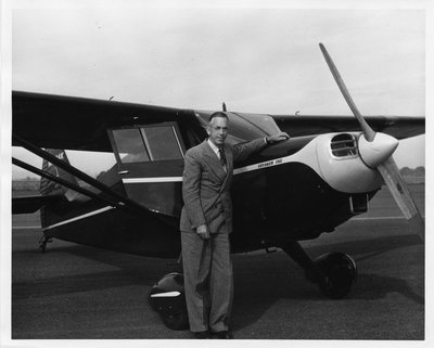Black and white photograph of August LeRoy Strand with a Voyager 150 plane.